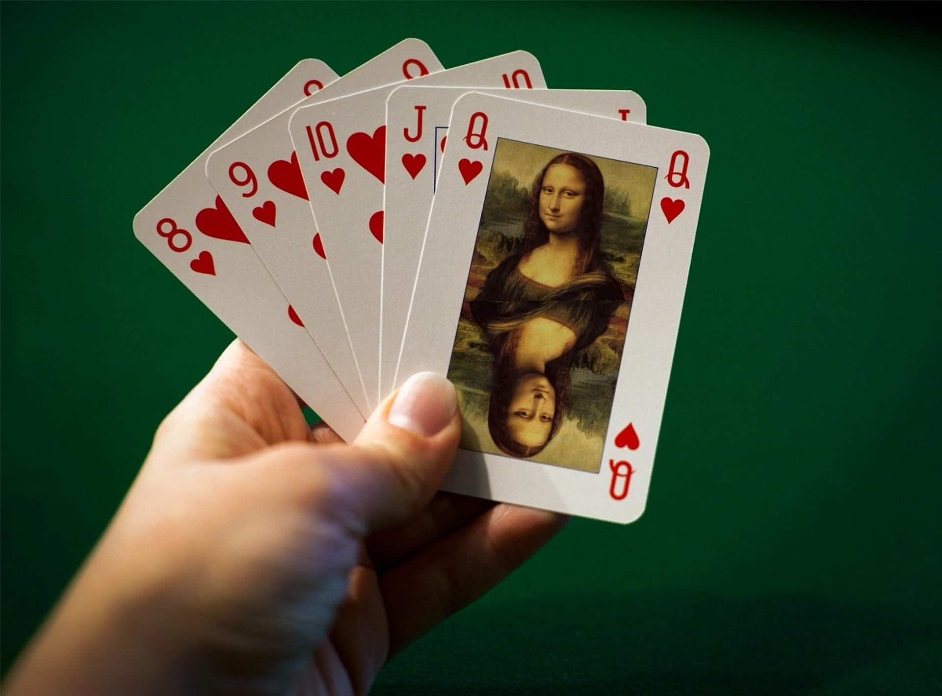 Jemand hat Spielkarten in der Hand, mit einer Abbildung von Mona Lisa